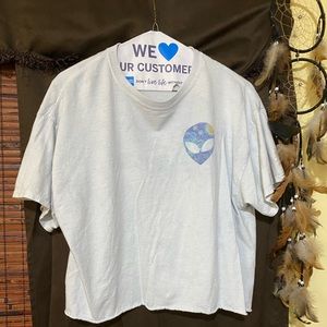 A cropped white tee with 2 alien faces on it